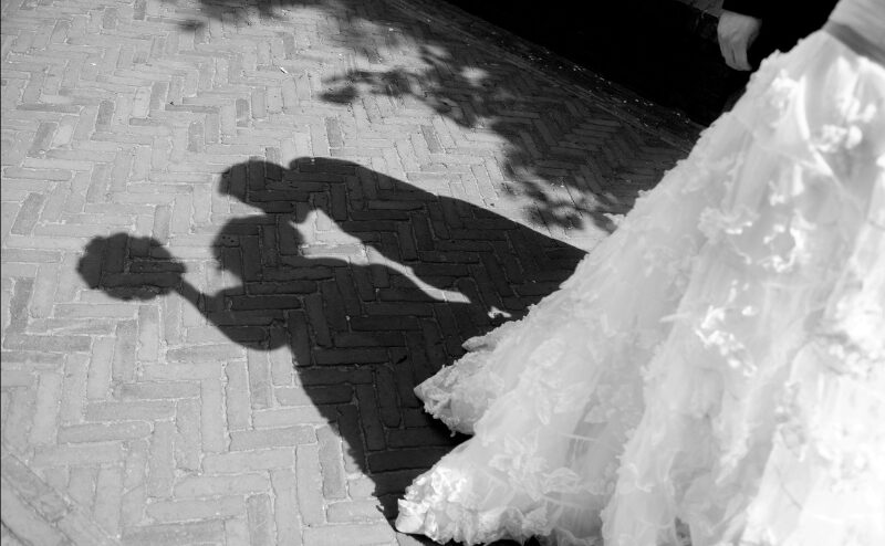 披露宴会場で円卓を囲みながら談笑するゲストたちと、ステージで笑顔の新郎新婦が登場する瞬間。