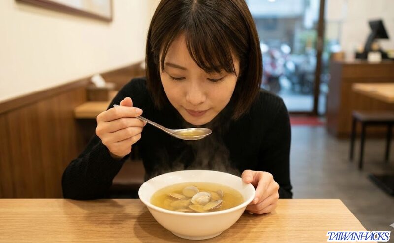 台湾の食堂で、体に優しい薬膳スープ(ハマグリと鶏肉のスープ)を一人で味わい、内側から癒やされる日本人女性